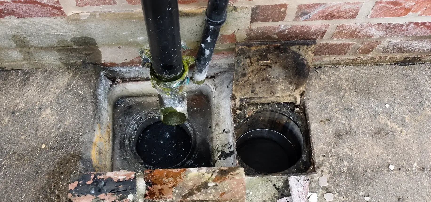 Open drainage chambers with grease and debris built up on the pipe walls