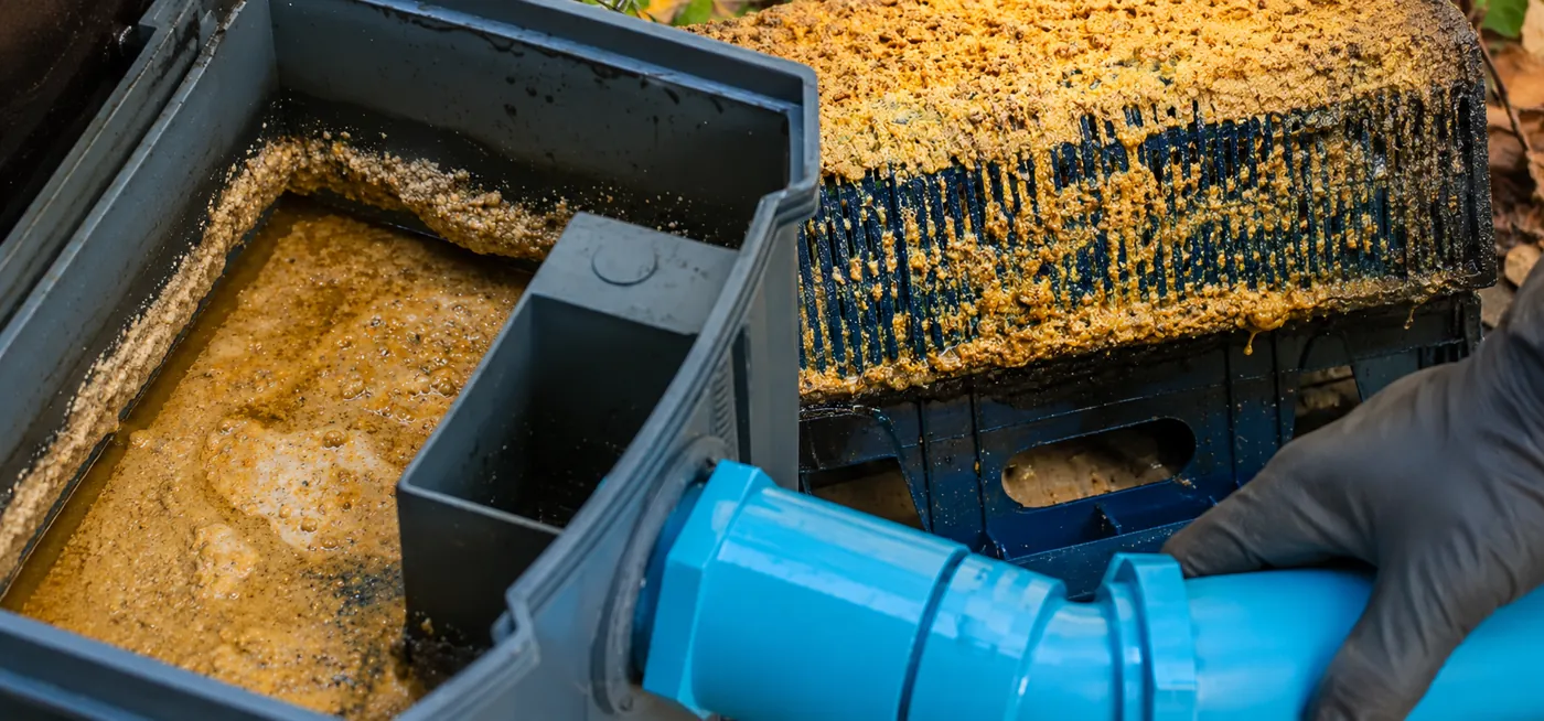 An opened grease interceptor showing accumulated fat and grease