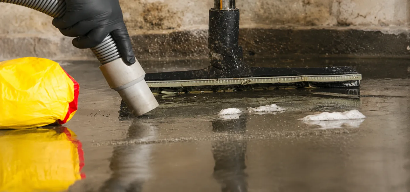A wet vacuum nozzle recovering standing water from a floor